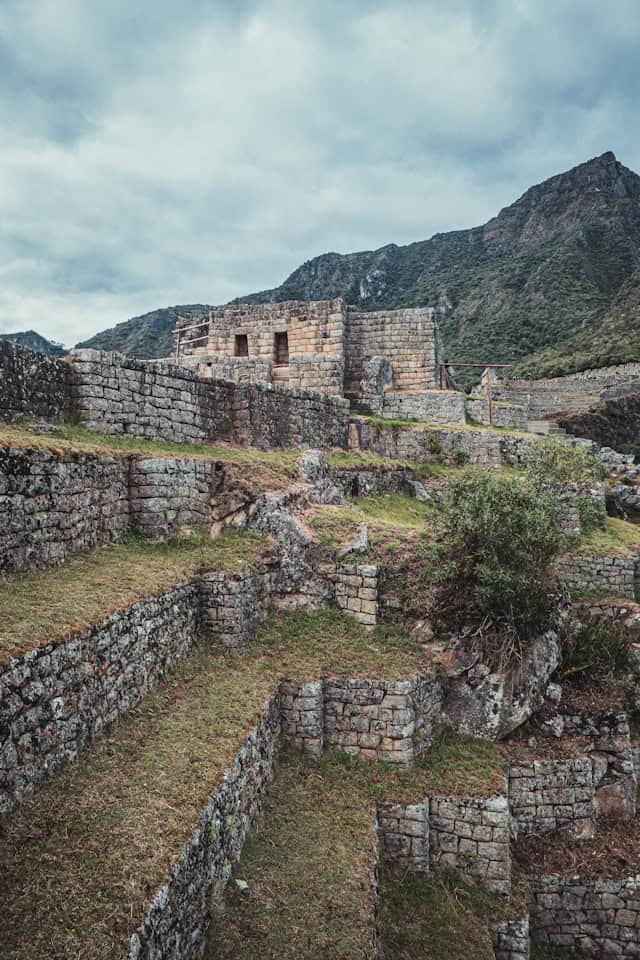 Ancient Incan ruins at Machu Picchu in Peru, showcasing stone terraces and historic archaeological sites with mountain backdrop, perfect for destination wedding travel photography.