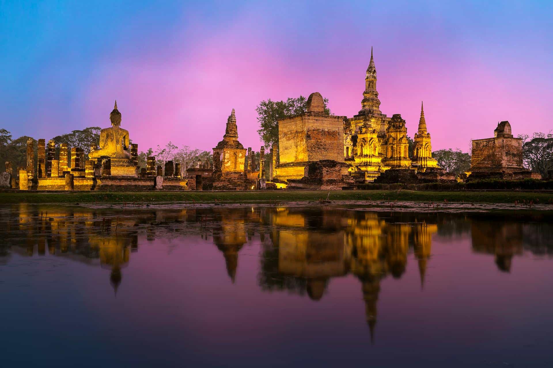 anniversaries-img-02 Ancient Thai temples illuminated at dusk with reflection in water, showcasing Thailand travel and cultural heritage. Beautiful sunset scene at historic landmark, perfect for travel destination inspiration.