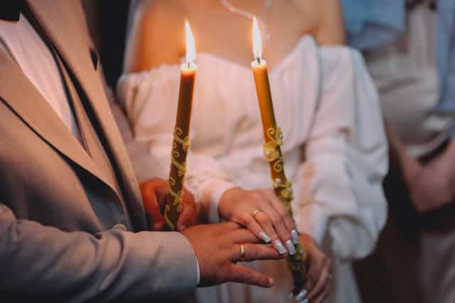 Agnostic candlelit wedding ceremony with couple holding candles during their special day in a serene, romantic setting.